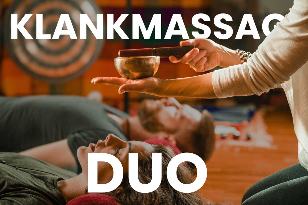 Behandelaar houdt een klankschaal boven liggende deelnemers — webshopafbeelding voor klankmassage DUO